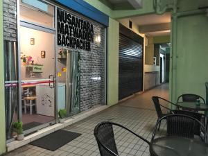 哥打京那巴鲁Nusantara Mattwaddien Hostel的餐厅在窗户前设有桌椅