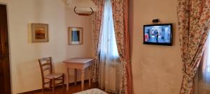 诺格拉Hotel Il Casolare的一间房间,墙上有桌子和电视