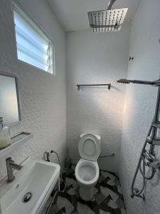 瓜拉丁加奴A’Casa Cottage的白色的浴室设有水槽和卫生间。