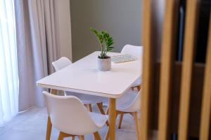 ZipárionOlivo Home的一张白色的桌子,上面有白色的椅子和植物