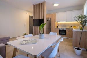 ZipárionOlivo Home的厨房以及带白色桌椅的用餐室。
