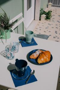 福尔米亚A Casa Scipione的一张桌子,上面放着蓝盘和杯子,还有羊角面包