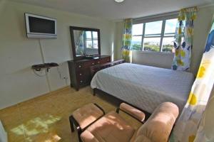 法哈多Pena Mar Ocean Club Best Views的一间卧室配有一张床、一把椅子和电视