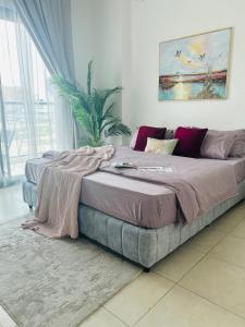 迪拜1-Bedroom Apartment Rental Unit With Pool in Dubai Land Residence Complex Dubai Al Ain Road的一间卧室配有一张大床,床上有毯子