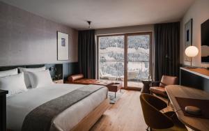 巴德加斯坦The Comodo Bad Gastein, a Member of Design Hotels的酒店客房设有一张床和一个大窗户