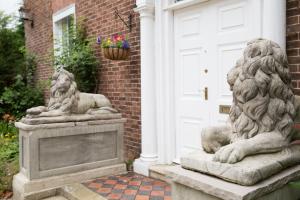 SetcheyThe Grange Manor House, Norfolk的两座石狮雕像,在房子前面