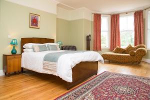 SetcheyThe Grange Manor House, Norfolk的一间卧室配有一张大床和一张沙发