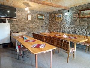 AreniLuiza Guest House的一间设有木桌和石墙的用餐室