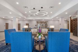 奥兰多Pestana Orlando Suites - Lake Buena Vista的一间等待室,配有蓝色的椅子和沙发