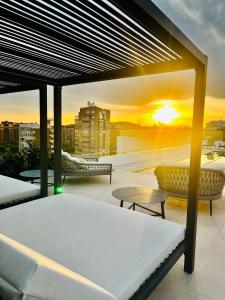 阿利坎特Port Alicante City & Beach的阳台配有床和桌子,享有日落美景