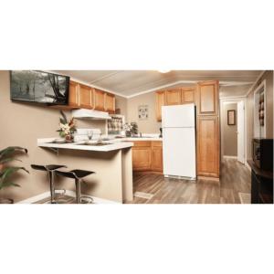 WhitfieldSunburst RV Resort的厨房配有白色冰箱和木制橱柜。