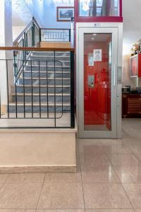 普拉亚·阿马勒雷克斯酒店的通往红色门和楼梯的大楼的入口