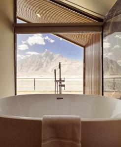 ShigarKhoj Resorts的带浴缸的浴室和大窗户
