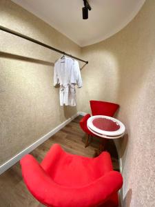 纳韦甘蒂斯Navega Beach Palace Hotel的一间房间,配有红色椅子、桌子和白色衬衫