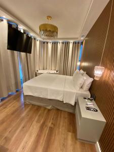 纳韦甘蒂斯Navega Beach Palace Hotel的一间卧室配有一张床、一张桌子和一台电视