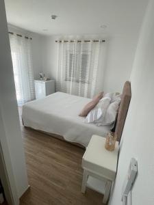 赞布热拉-杜马尔Alojamento Sudoeste的白色卧室配有床和桌子