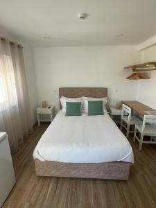 赞布热拉-杜马尔Alojamento Sudoeste的一间卧室配有一张大床和一张桌子