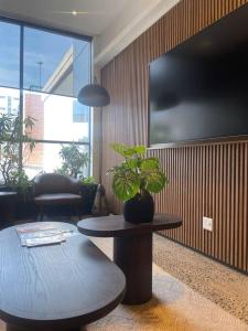 德班Umhlanga Arch Sea View Apartment的客厅配有桌子和盆栽植物