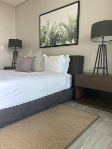 德班Umhlanga Arch Sea View Apartment的一间卧室配有一张带两盏灯的床。