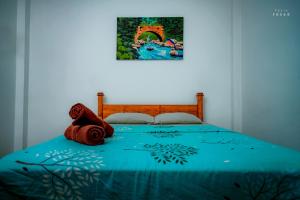 奇洛Hotel Athina & Restaurant的一张带蓝色被子的床铺和墙上的绘画