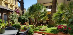 罗马格林酒店的一个带棕榈树和桌椅的花园