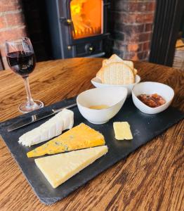 胡克The New Inn Heckfield的桌上放一盘奶酪和一杯葡萄酒