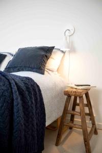 埃斯比约赫耶汀巴德酒店的一张带蓝色毯子的床和一个带灯的凳子