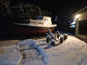 Grobiņa100SaulesVikingi的夜间停泊在雪地中的船只