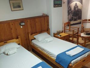 干尼亚Guesthouse Chryssoula的一间卧室配有两张床和一张桌子及椅子
