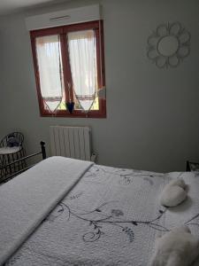 PendéLa salicorne的卧室配有一张大白色床和窗户