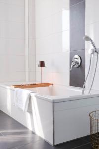 因戈尔施塔特Lumen Homes - Design-Apt. nahe Audi und Altstadt, 3 Zimmer, NETFLIX的白色的浴室设有浴缸和水槽。