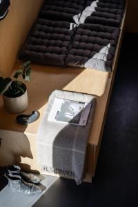 ÅrnesTiny House in the countryside的一张带毯子和鞋的桌子床