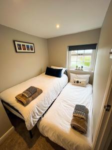 劳斯Auctioneers Cottage的小客房内的两张床和毛巾
