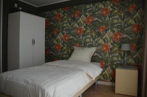 佐内贝克B&B The Protea的一间卧室配有一张带花卉壁纸的床