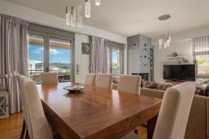 诺亚福克Sea Wind Luxury Villa with Private Heated Pool Kassandra Halkidiki的一间带木桌和椅子的用餐室