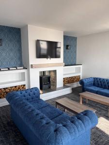 波斯考尔海畔酒店的客厅配有蓝色的沙发和电视