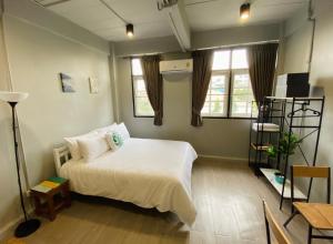 曼谷Bangpho Story的卧室配有白色的床和2扇窗户。