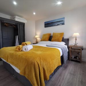 海滨韦尔斯港AnchorageWells Lodge, Seaview Apartment的一间卧室配有一张带黄色毯子的大床