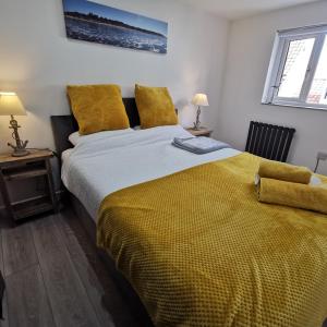 海滨韦尔斯港AnchorageWells Lodge, Seaview Apartment的一间卧室配有一张带黄色毯子的大床