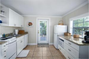 拉斯金Pirates Pointe Resort的厨房配有白色橱柜和白色冰箱。