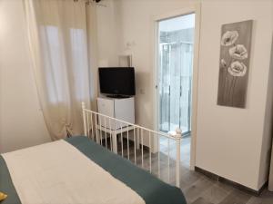 SovioreAffittacamere Ca der Culunellu的一间卧室设有一张床、一台电视和一个阳台。