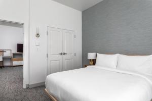 奥兰多TownePlace Suites By Marriott Orlando Southwest Near Universal的卧室配有一张白色大床和一个衣柜