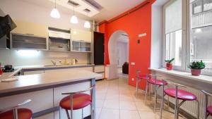 利沃夫利沃夫欧乐旅馆的厨房设有红色的墙壁和酒吧凳子