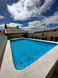 卡里翁德洛斯孔德斯Hostal Comfort Suites的一座大蓝色游泳池,位于房子前