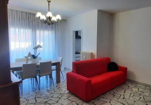 特伦托Verdisuite - Trento centro - Parcheggio privato gratuito的客厅配有红色的沙发和桌子