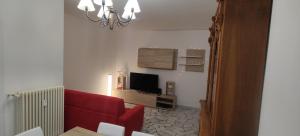 特伦托Verdisuite - Trento centro - Parcheggio privato gratuito的客厅配有红色沙发和电视