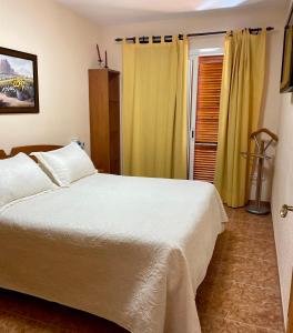 佩尼斯科拉Los Alamos Somhome的卧室配有白色的床和黄色窗帘
