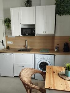内尔哈Casa Eva - Adults Only的厨房配有白色橱柜、桌子和微波炉