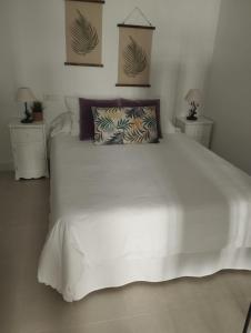 内尔哈Casa Eva - Adults Only的一间卧室配有一张带2个床头柜的大型白色床