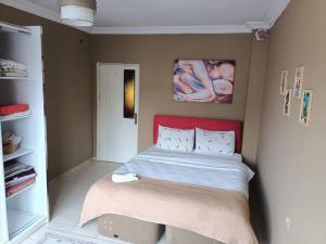 安塔利亚Lara plaj yakın Aileler için 1+1 mükemmel daire的一间卧室配有一张红色床头板的床